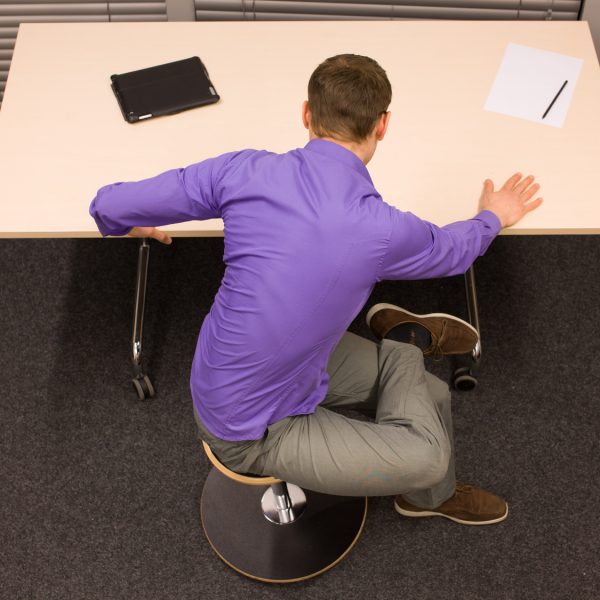 man exercising during short breake in work at his desk in office