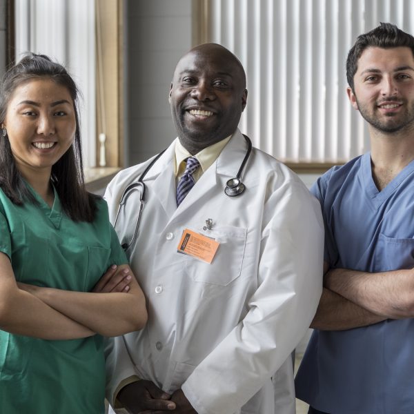 Portrait of a proud Asian female nurse, Caucasian male nurse, and African American doctor